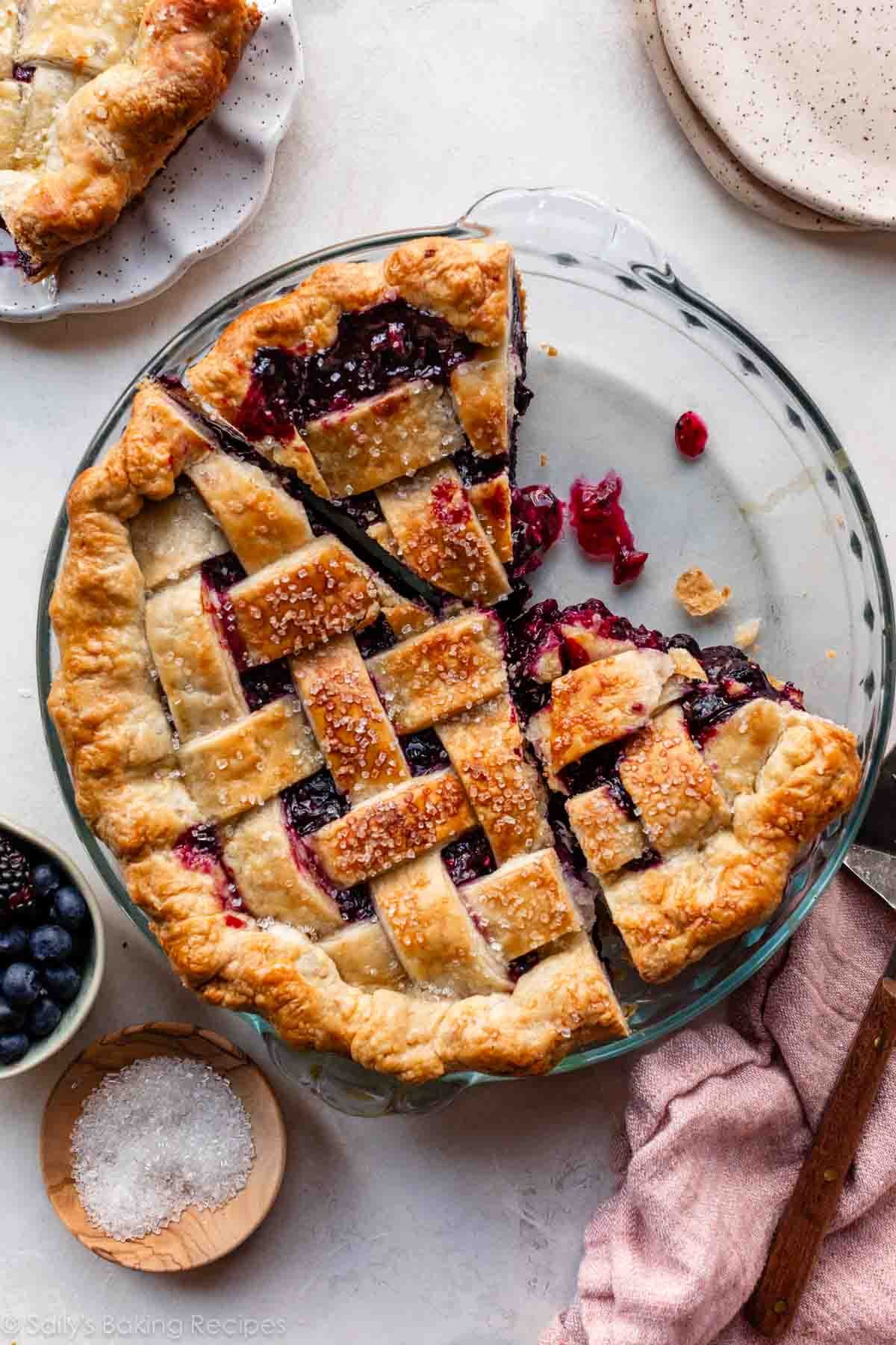 triple berry pie with some slices cut out.