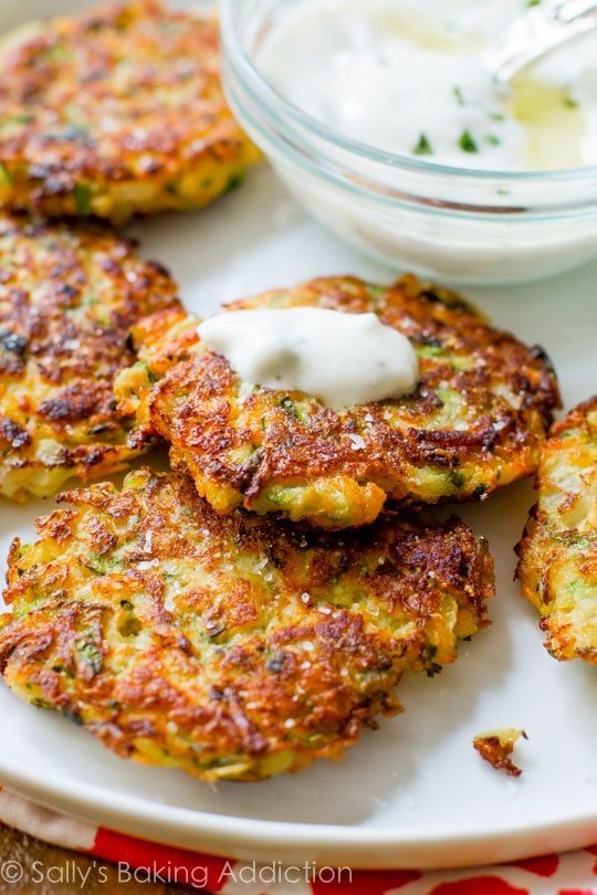 zucchini fritters with yogurt sauce on a white plate